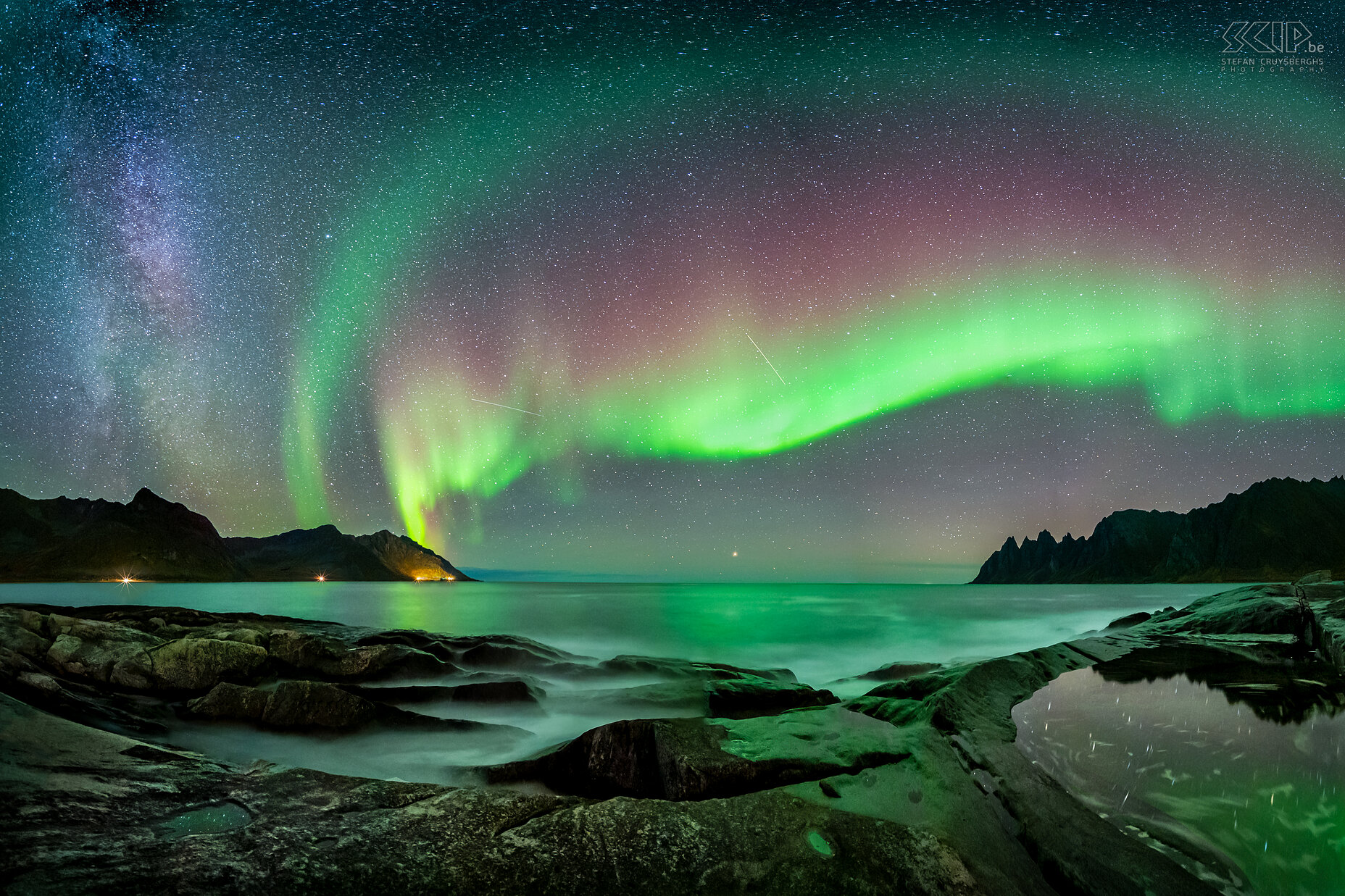 Senja - Tungeneset - Noorderlicht Een panoramabeeld van een magische nacht op de rotsen van Tungeneset op het eiland Senja. Het noorderlicht (aurora borealis) was heel actief met wonderlijke groene en rode kleuren, de melkweg was nog zichtbaar en mijn camera legde ook enkele vallende sterren vast. De heldere ster aan de horizon in het midden van de afbeelding is Arcturus. Stefan Cruysberghs